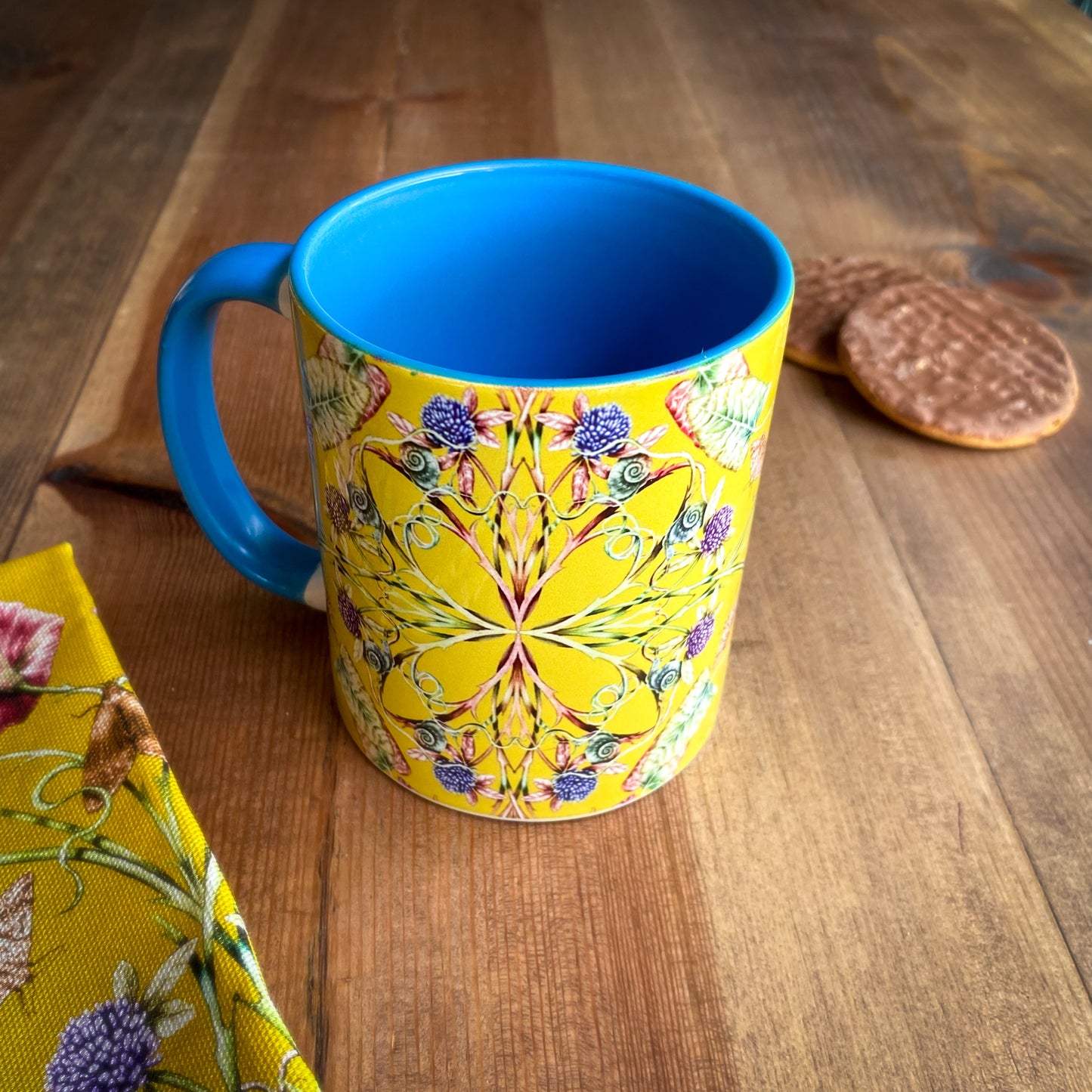 Colorful mug with blue handle on a wooden surface