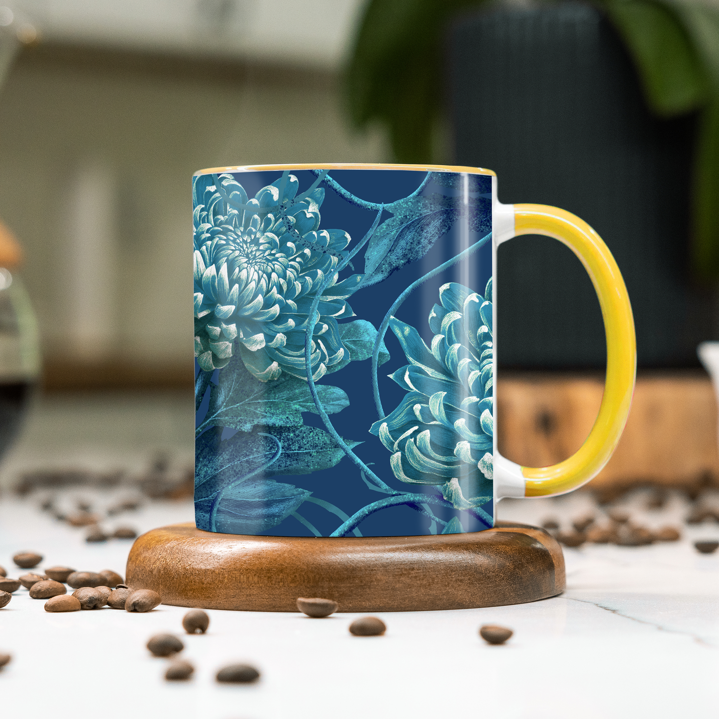 Mug with blue floral design and yellow handle on a wooden coaster with coffee beans around