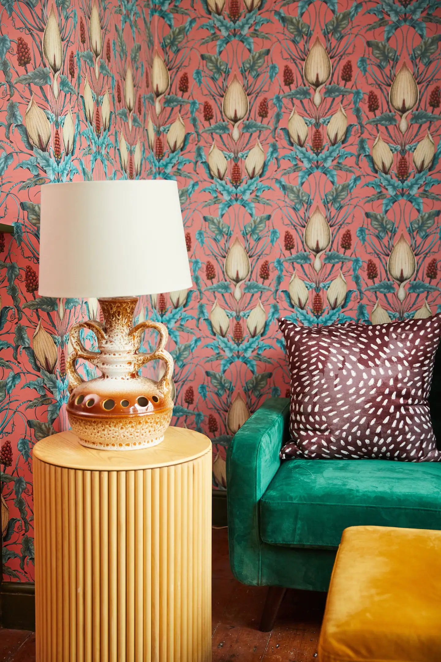 Room in the Old Stout House in Rye Sussex, featuring April Mawhinney's Lords and Ladies wallpaper in Penicillin Pink. There is a green velvet sofa and a vitage lampbase with a cream lampshade. House is owned and decorated by Interior Designer Nicola Gill, and photograph is copyrighted to Rachael Smith Photography