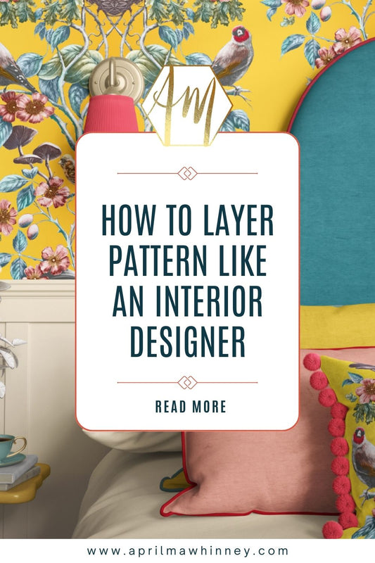 April Mawhinney's Gold Finch wallpaper on a bedroom wall, a bed in front with colourful pillows and text overlaid which reads How to Layer pattern like an interior designer