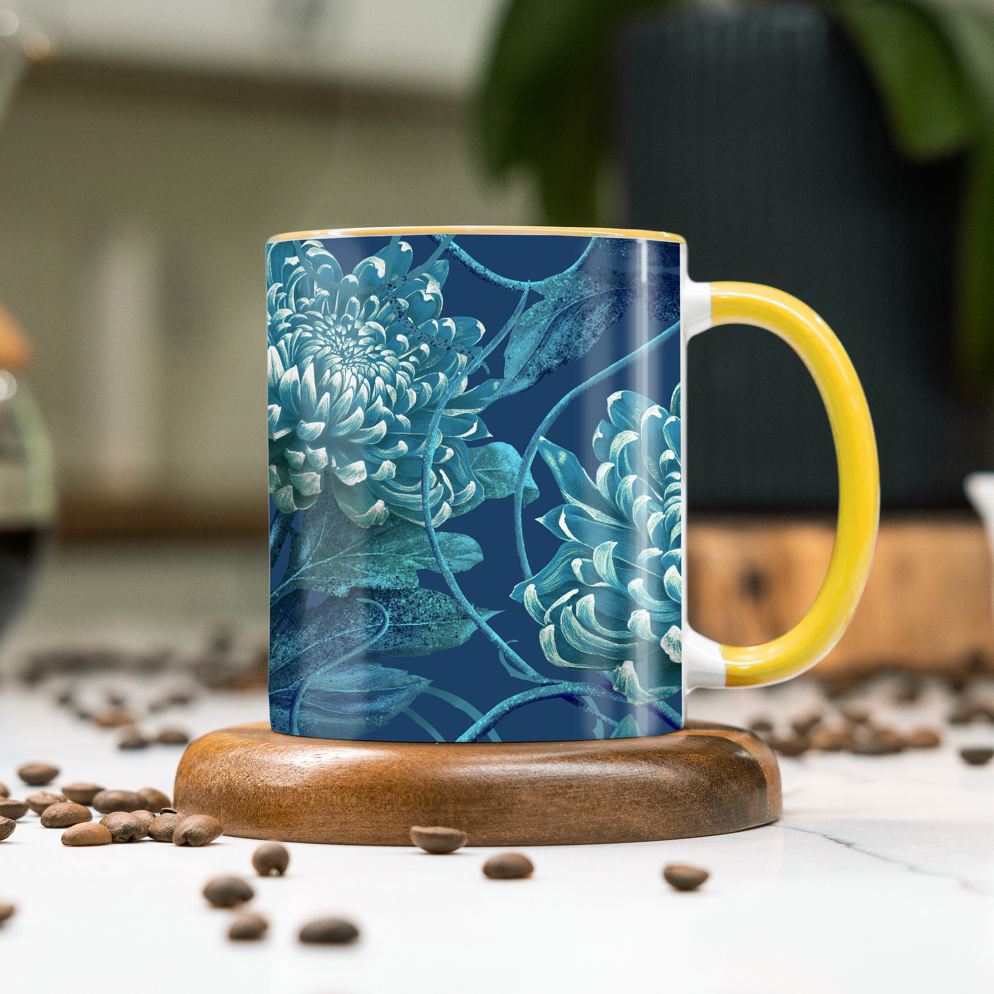 Mug with blue floral design and yellow handle on a wooden coaster with coffee beans around