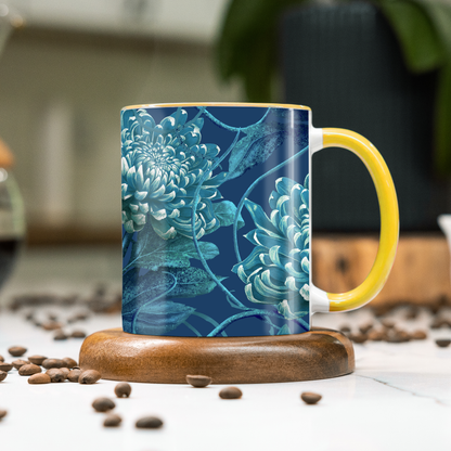 Mug with blue floral design and yellow handle on a wooden coaster with coffee beans around