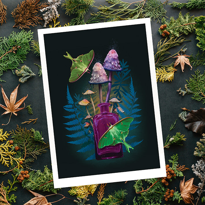 A square art print with a white border showing a dark illustration of purple mushrooms and green leaves around a purple glass bottle, photographed from above on a dark background surrounded by evergreen branches and dried leaves.
