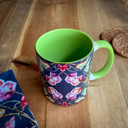 11oz ceramic navy mug with green handle and green colour inside. Printed in the UK with illustrated moths, bind weed, ivy and snails.