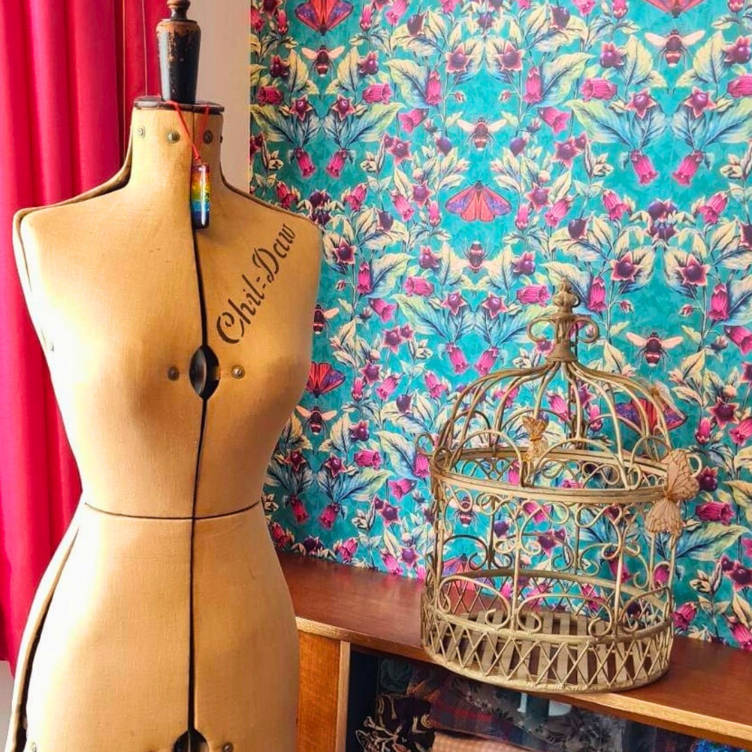 Guest Bedroom and Craft Room, Deadly Nightshade Wallpaper in Arsenic, vintage sewing mannequin and mid century cabinet in the forground.