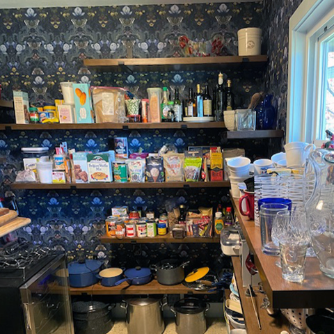 Pantry, New Jersey, USA, Bloomsbury Moth Wallpaper with vintage oak shelving and produce stored.