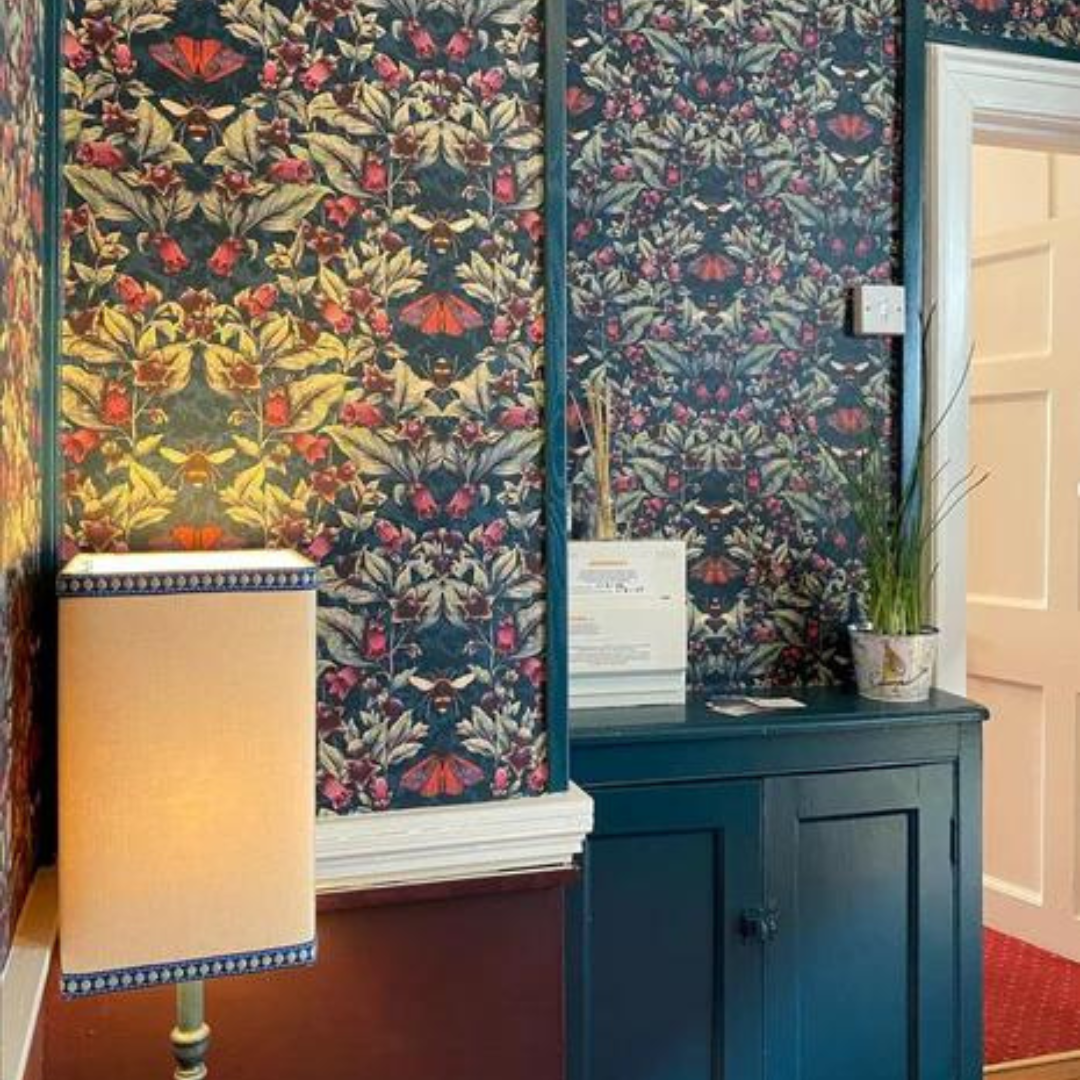 Showroom Business Foyer, Deadly nightshade wallpaper in Midnight. With Farrow and Ball Stiffkey Blue woodwork and cream table lamp. Emsworth, West Sussex, UK