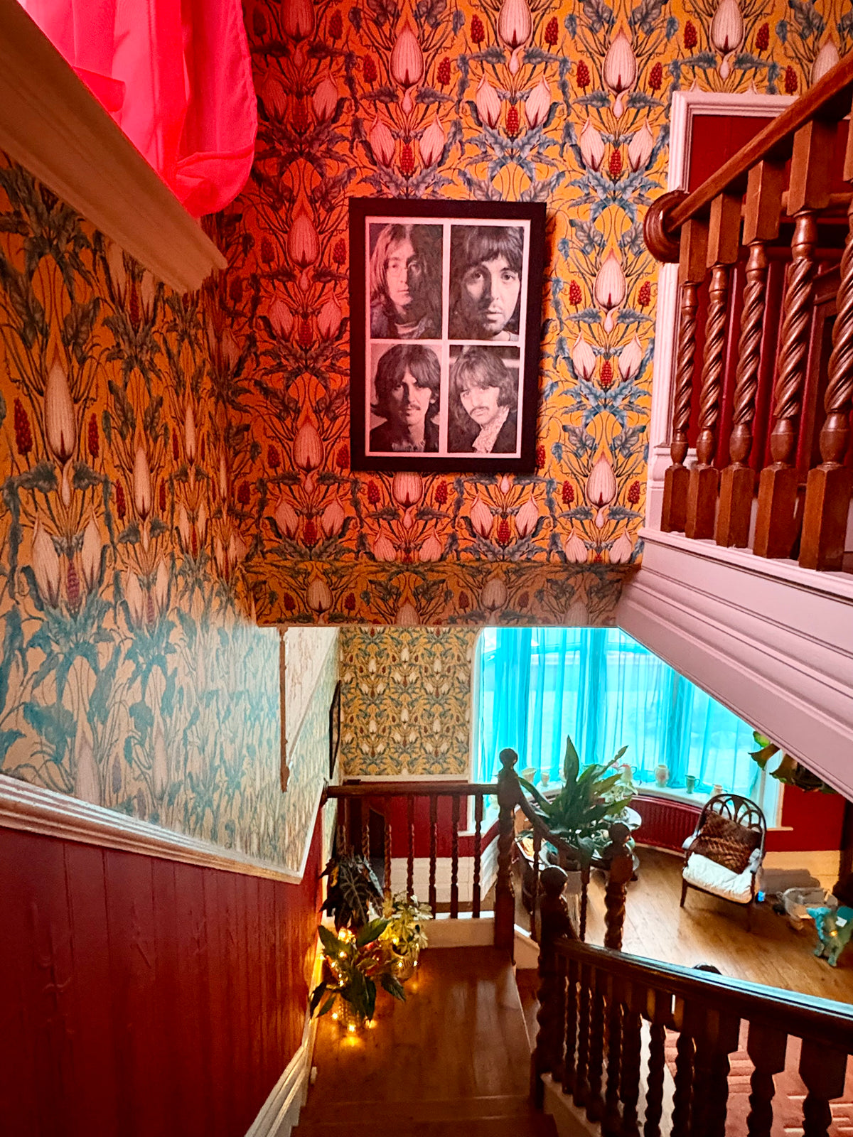Staircase with Lords and Ladies wallpaper in Alchemist Yellow and a framed picture of the Beatles